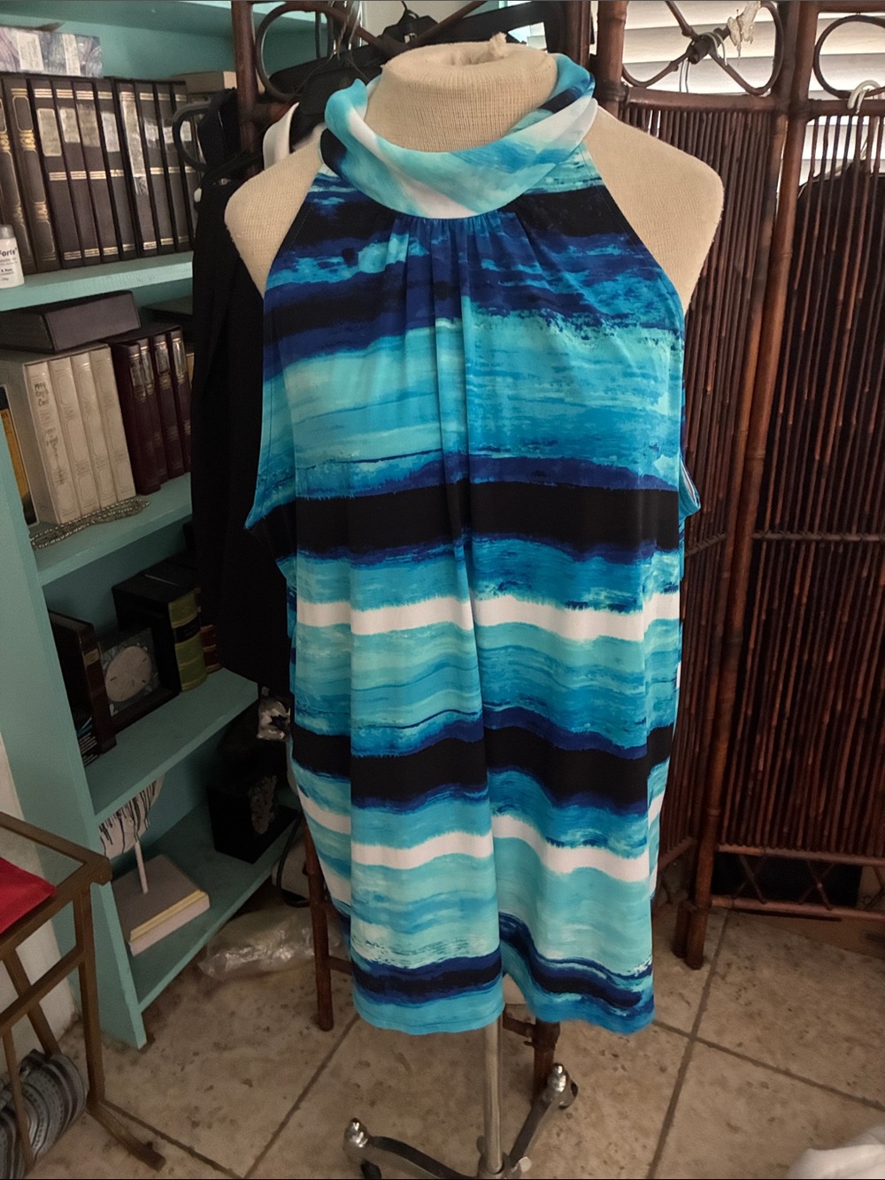 TheLimited sleeveless length top with side slits. Rolled collar with back tie.